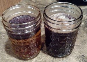 two small mason jars with coffee on a counter