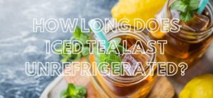 glass of iced tea with a straw. herbs and lemon decorate the background