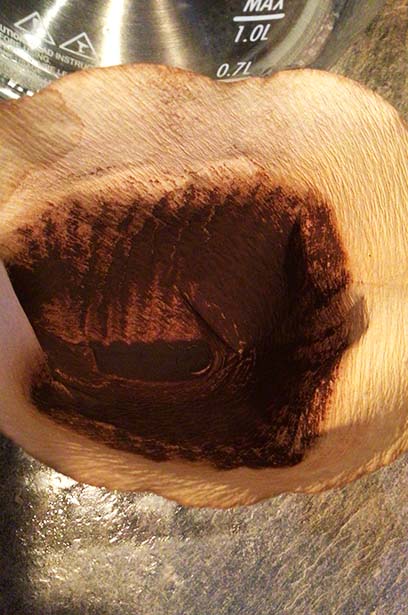 paper coffee filter with fine coffee grounds in it