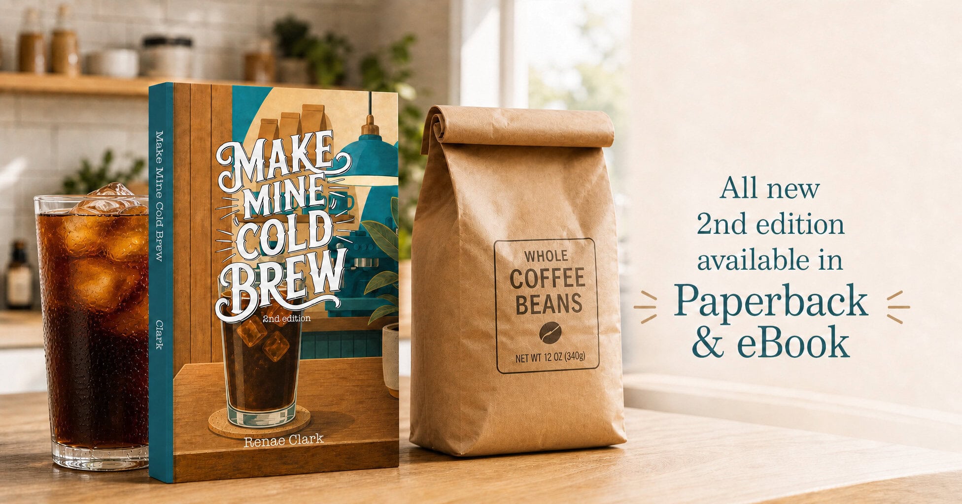 book on a wooden counter "Make Mine Cold Brew 2nd edition" flanked by a glass of iced cold brew coffee and a plain paper bag of coffee beans.